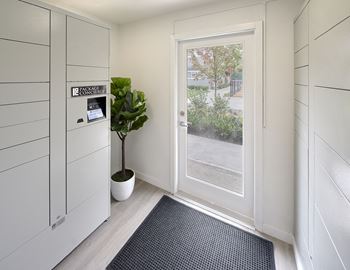 Package concierge with a door and a sunny window. Light gray package lockers to the left. at 3030 Lake City, Seattle, WA, 98125